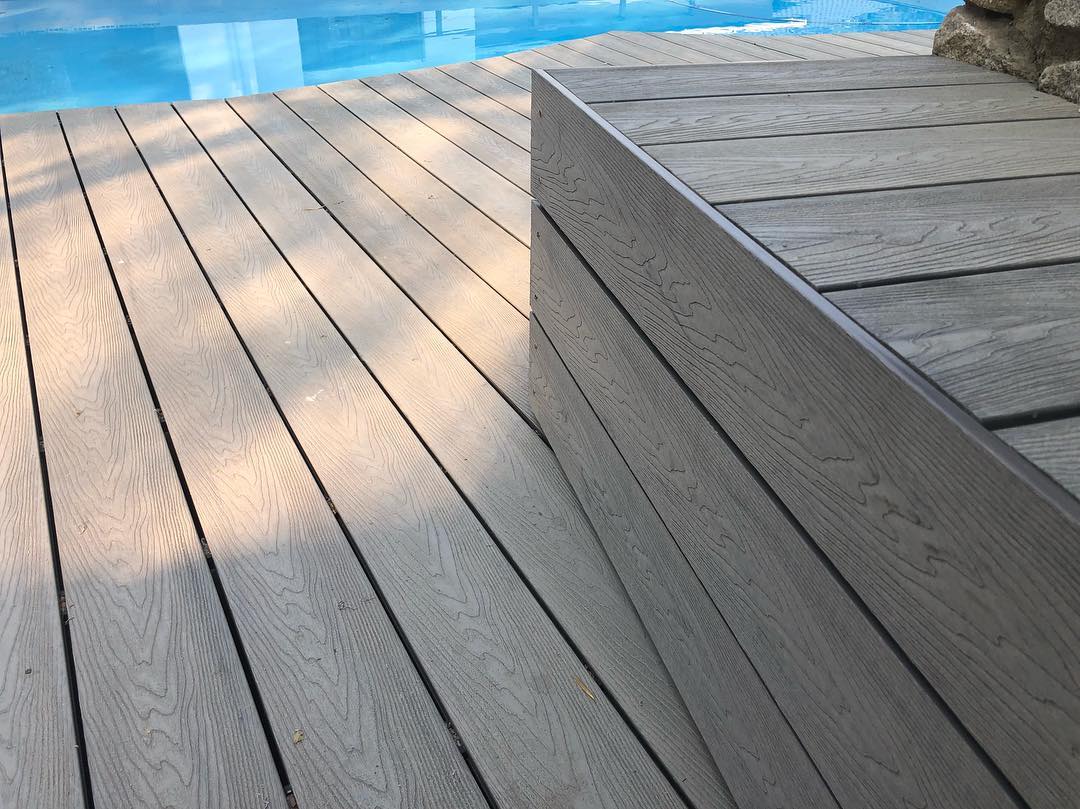 Composite decking with a wood-grain finish, installed with hidden fasteners for a seamless look.