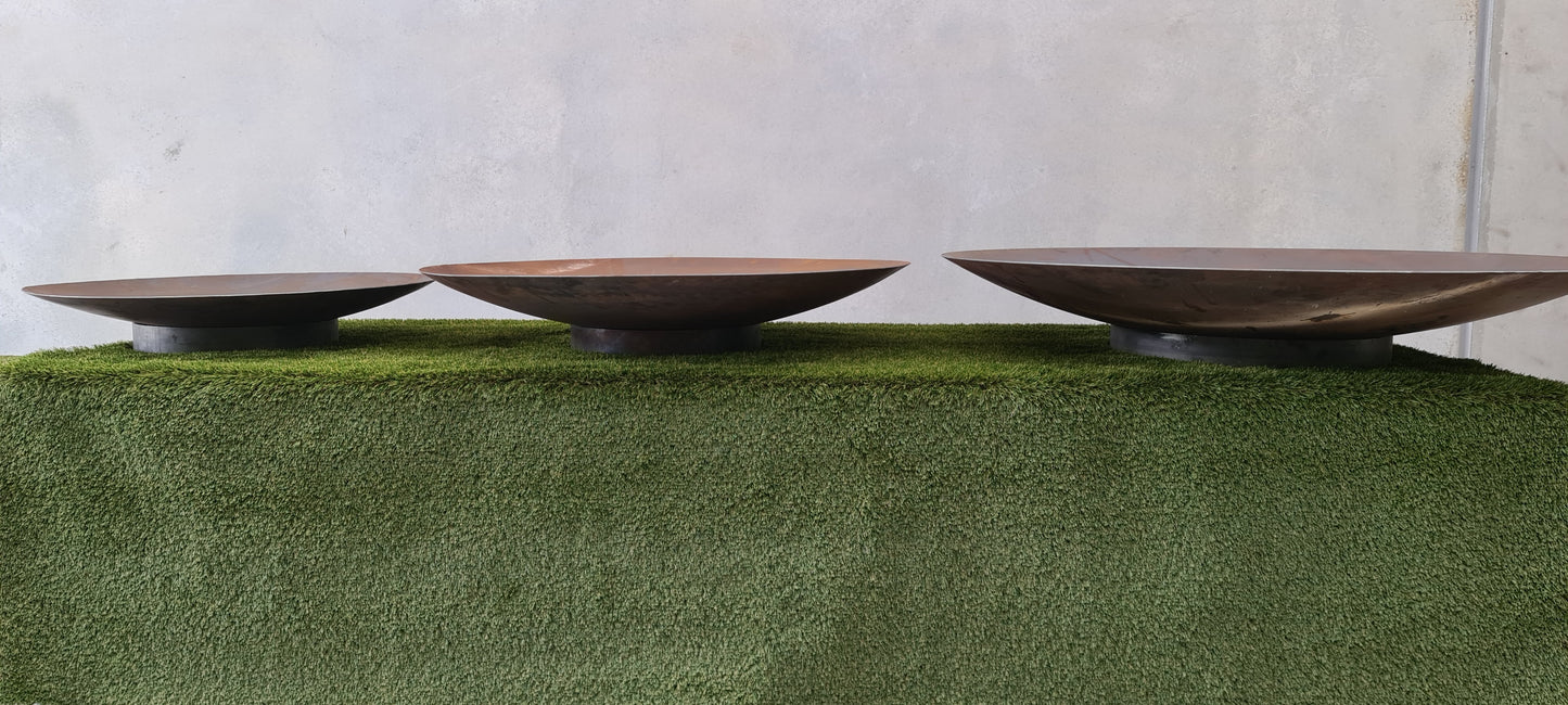Three Corten steel fire pits showing the different sizes.