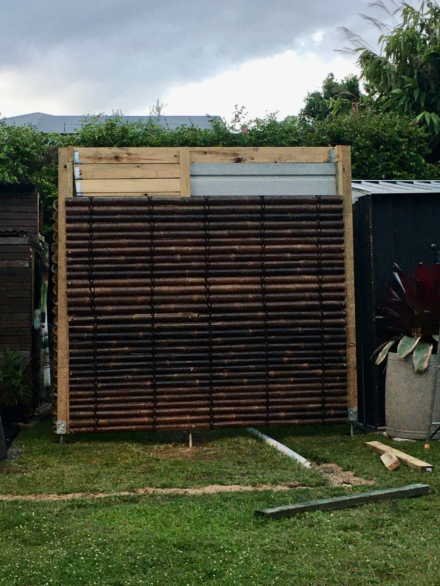 the bamboo  screens are installed to cover up a shed.