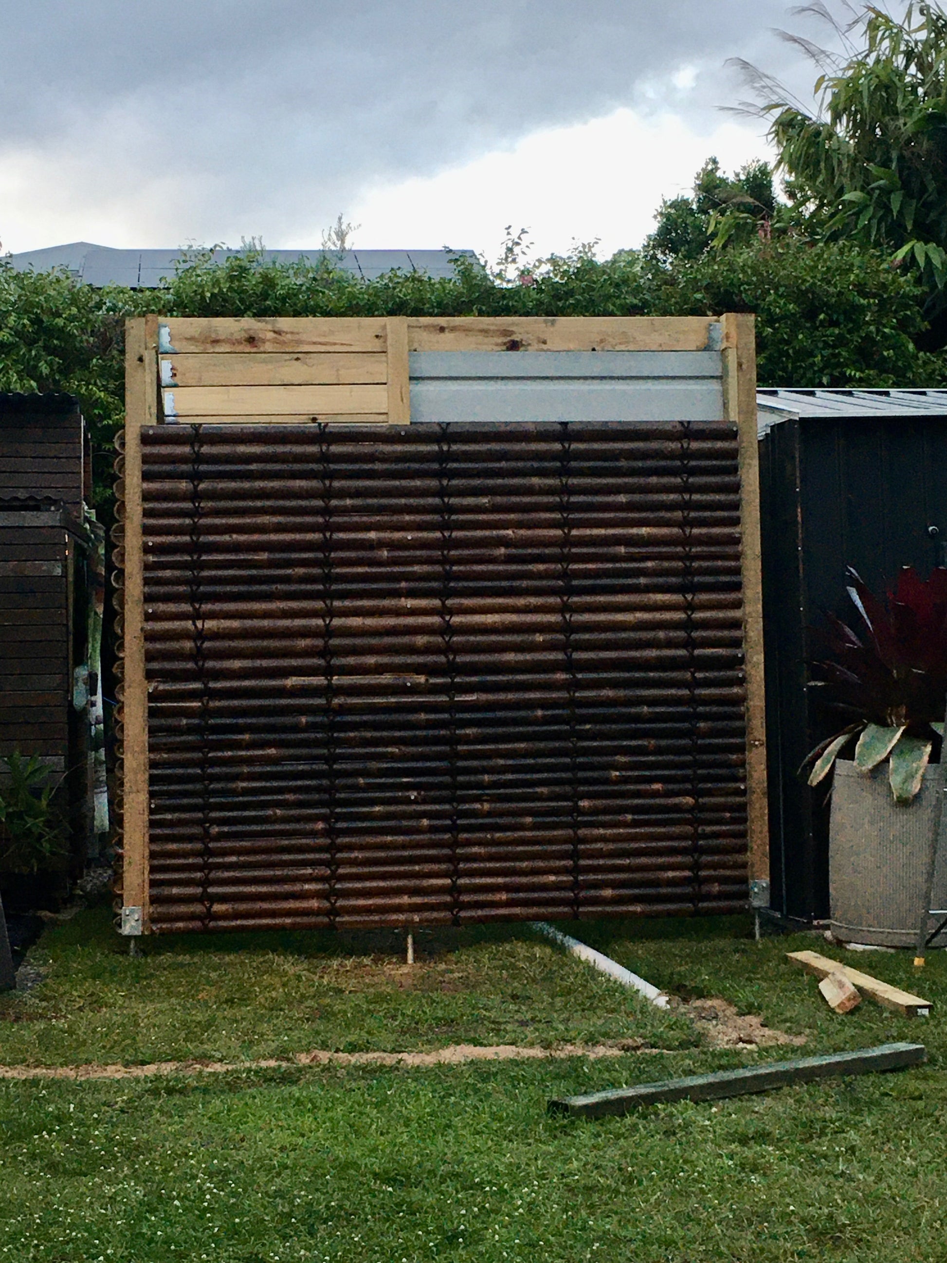 the bamboo  screens are installed to cover up a shed.