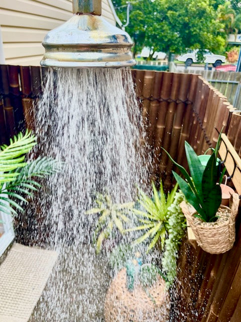 a shower area has been created from bamboo next to a pool.